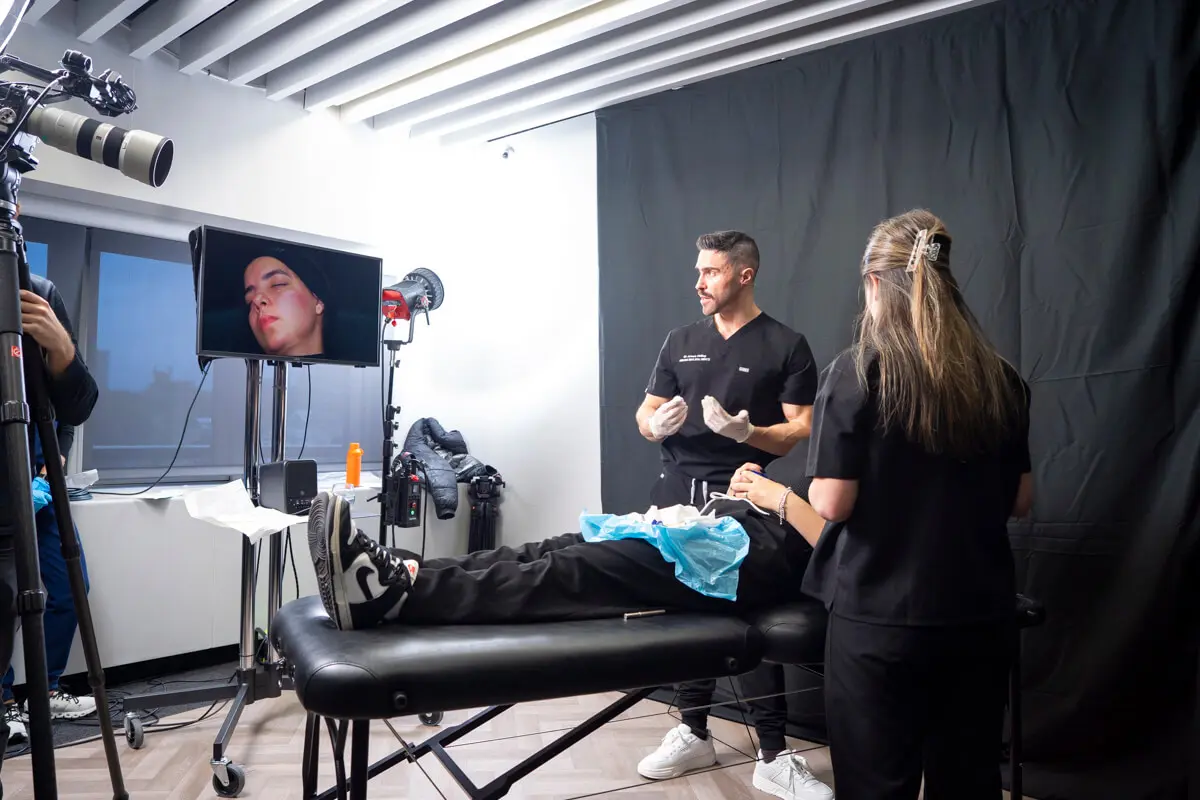 Dr James Olding is presenting an aesthetics treatment during Interface Expo. The face of a patient is broadcast live on TV.