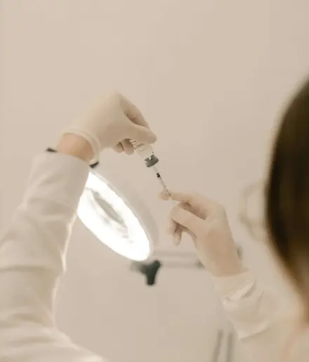 Aesthetic medicine injection. A practitioner holds a seringe in their hands.