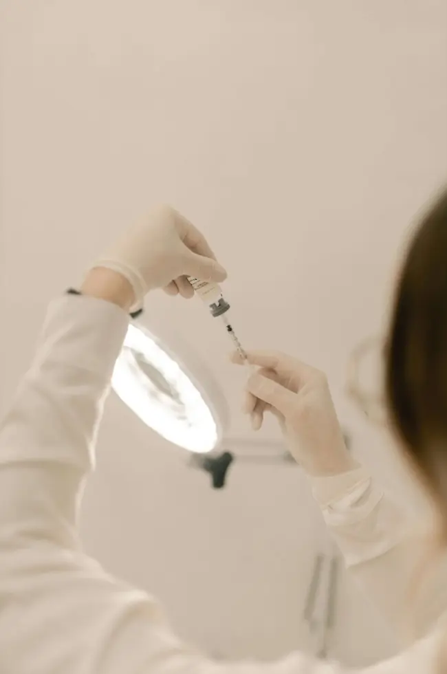 Aesthetic medicine injection. A practitioner holds a seringe in their hands.